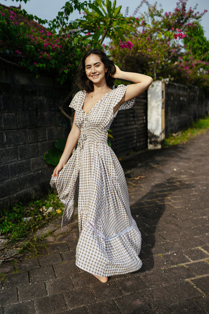 
                  
                    Featuring an open back and button down front with a shirred waist. 100% Rayon
                  
                