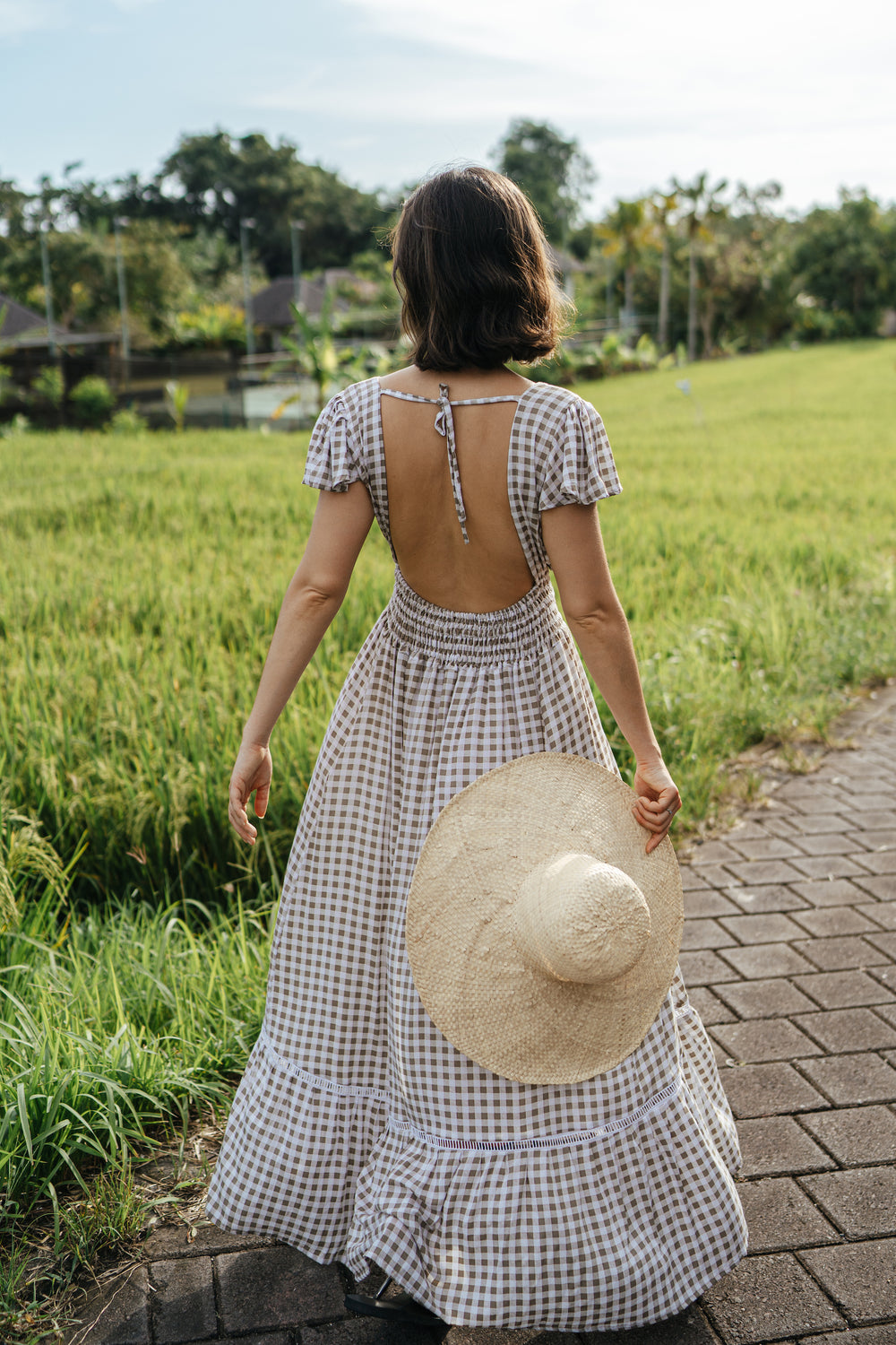 Featuring an open back and button down front with a shirred waist. 100% Rayon