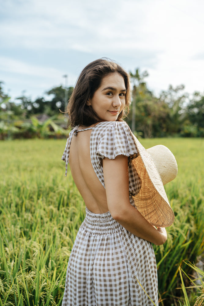 
                  
                    Featuring an open back and button down front with a shirred waist. 100% Rayon
                  
                